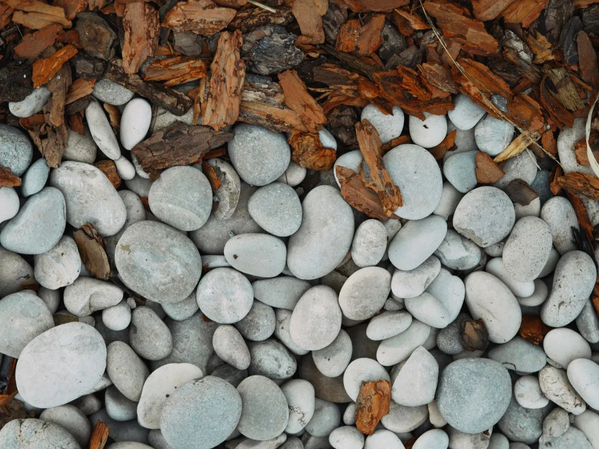 Smooth gray landscape stones beside brown bark mulch